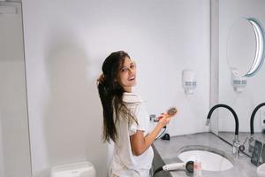 belle jeune femme dans la salle de bain tenant un sèche-cheveux photo