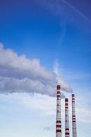 la pollution de l'air. cheminées fumantes contre le ciel bleu. photo