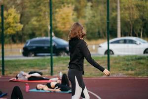 jeune femme en forme de vêtements de sport s'entraîne à l'extérieur sur l'aire de jeux. photo