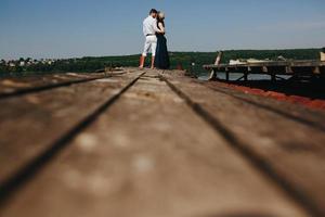 étreindre homme et femme amoureux sur une jetée en bois photo