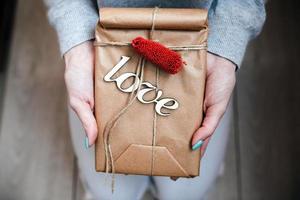 la jeune fille tient dans les mains un charmant cadeau pour son bien-aimé photo