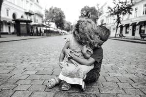 petit garçon et fille sont assis dans la rue photo