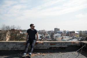 l'homme aux authentiques bottes et jeans lisière sur le toit de l'immeuble de la vieille ville photo