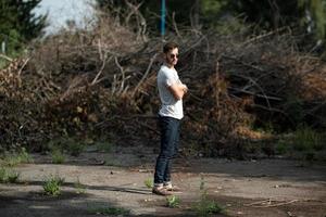 l'homme aux bottes authentiques et aux jeans selvedge sur fond de branches photo