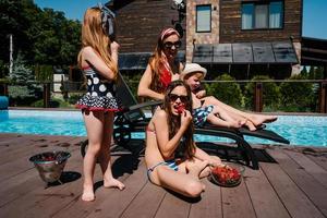 une belle famille se détend au bord de la piscine photo