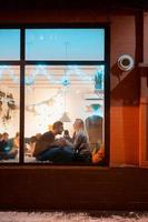 photo à travers la fenêtre. jeune couple au café avec un intérieur élégant