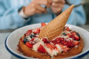 tarte fraîchement cuite avec diverses baies et crème glacée sur une assiette blanche. photo