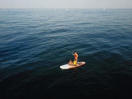 mère avec deux filles debout sur un paddle board photo