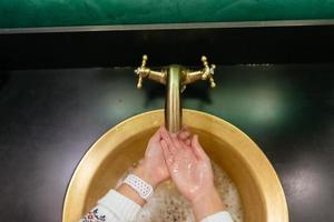 photo en gros plan d'une femme se lave les mains avec de l'eau et du savon.