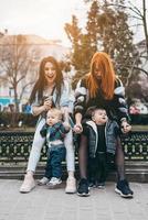 deux mamans et leurs deux garçons posant devant la caméra photo