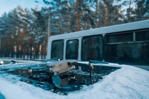 drone debout sur le toit d'une voiture enneigée photo