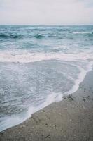 mer avec les vagues se brisant sur la plage créant des embruns. photo