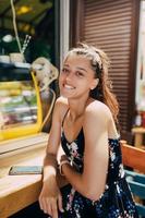 séduisante jeune femme caucasienne assise dans un café de rue photo