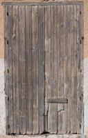 arrière-plan d'une vieille porte en bois fermée et patinée qui est au format portrait dans un vieux mur. photo