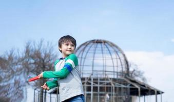 enfant heureux jouant dans le parc, enfant s'amusant à jouer dehors au printemps ensoleillé, écolier s'amusant avec un disque volant dans le champ en été, activité sportive et récréative en plein air pour les enfants concept photo