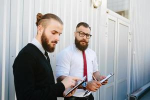 deux hommes d'affaires barbus regardant quelque chose photo