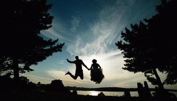 marié et mariée sautant contre le beau ciel photo