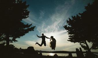 marié et mariée sautant contre le beau ciel photo