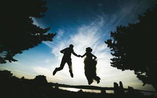 marié et mariée sautant contre le beau ciel photo