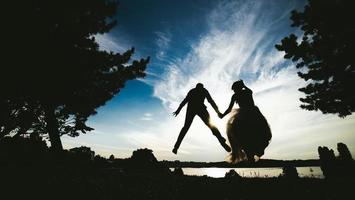 marié et mariée sautant contre le beau ciel photo