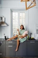 jeune jolie femme mangeant du gâteau dans la cuisine moderne. photo