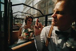 mariés posant dans une voiture de tourisme photo