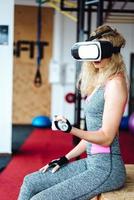 belle fille dans la salle de gym avec casque vr photo