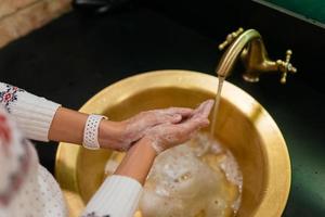 photo en gros plan d'une femme se lave les mains avec de l'eau et du savon.