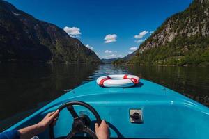 beau jeune homme contrôle un bateau à moteur sur un lac de montagne photo