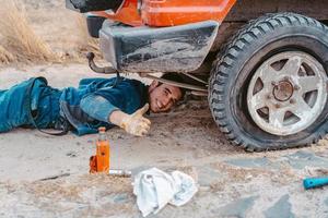 un homme soulève sur un cric 4x4 camion hors route photo