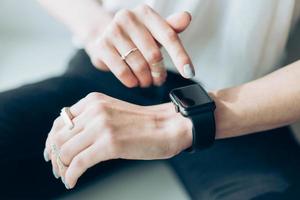 main de femme touchant l'écran d'une montre intelligente photo