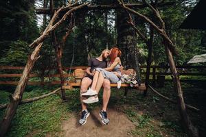 beau couple avec chien sur une balançoire photo