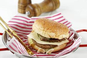 Hamburger au fromage haut de gamme fait maison sur plaque dorée, tableau blanc photo