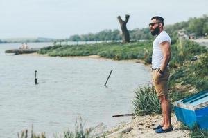 homme barbu américain regarde sur la rive du fleuve photo