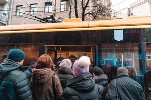 de nombreuses personnes non identifiées attendent le transport urbain à l'arrêt de bus photo