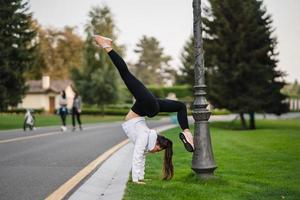 jolie femme maigre faisant un backbend tout en montrant un saut périlleux. photo