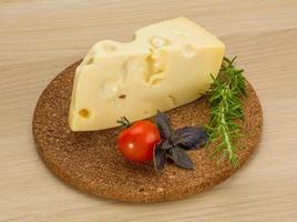 Fromage maasdam sur planche de bois et fond de bois photo