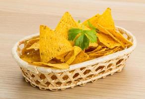 nachos dans un panier sur fond de bois photo