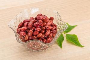 Haricots rouges dans un bol sur fond de bois photo