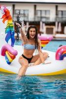 femme sur matelas gonflable licorne flotteur dans la piscine. photo