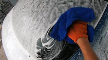 jeune homme lavant sa voiture après le shampoing en essuyant avec un chiffon photo
