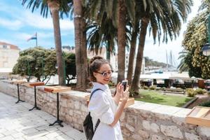 jeune fille marchant dans les anciennes rues étroites et prend une photo