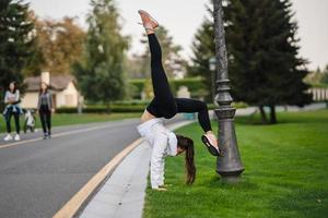 jolie femme maigre faisant un backbend tout en montrant un saut périlleux. photo