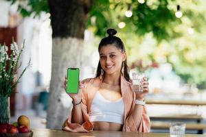 jeune femme tient un smartphone avec un écran vert photo
