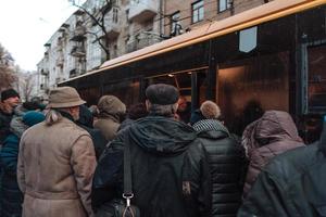 de nombreuses personnes non identifiées attendent le transport urbain à l'arrêt de bus photo