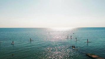 touristes flottant à bord du sup dans la mer bleue. agrafe. photo