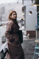 jolie femme en trench-coat sur la rue de la ville photo