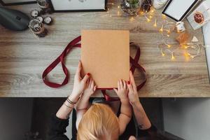 femme emballant présente dans du papier avec ruban rouge. photo