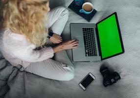 femme utilisant un ordinateur portable sur son lit photo