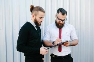 deux hommes d'affaires barbus signant des documents photo